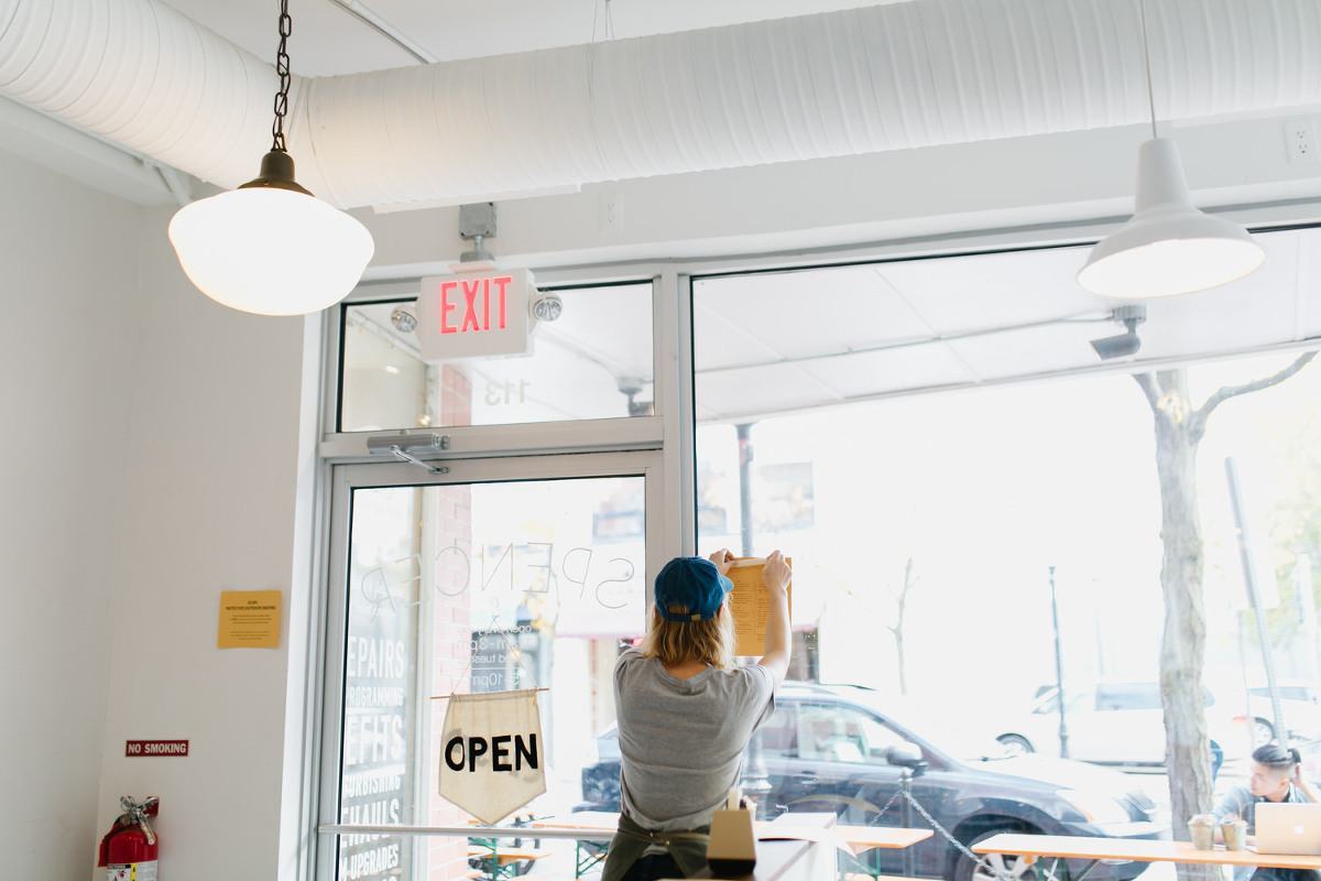 Staff hangs Open sign at Spencer Ann Arbor