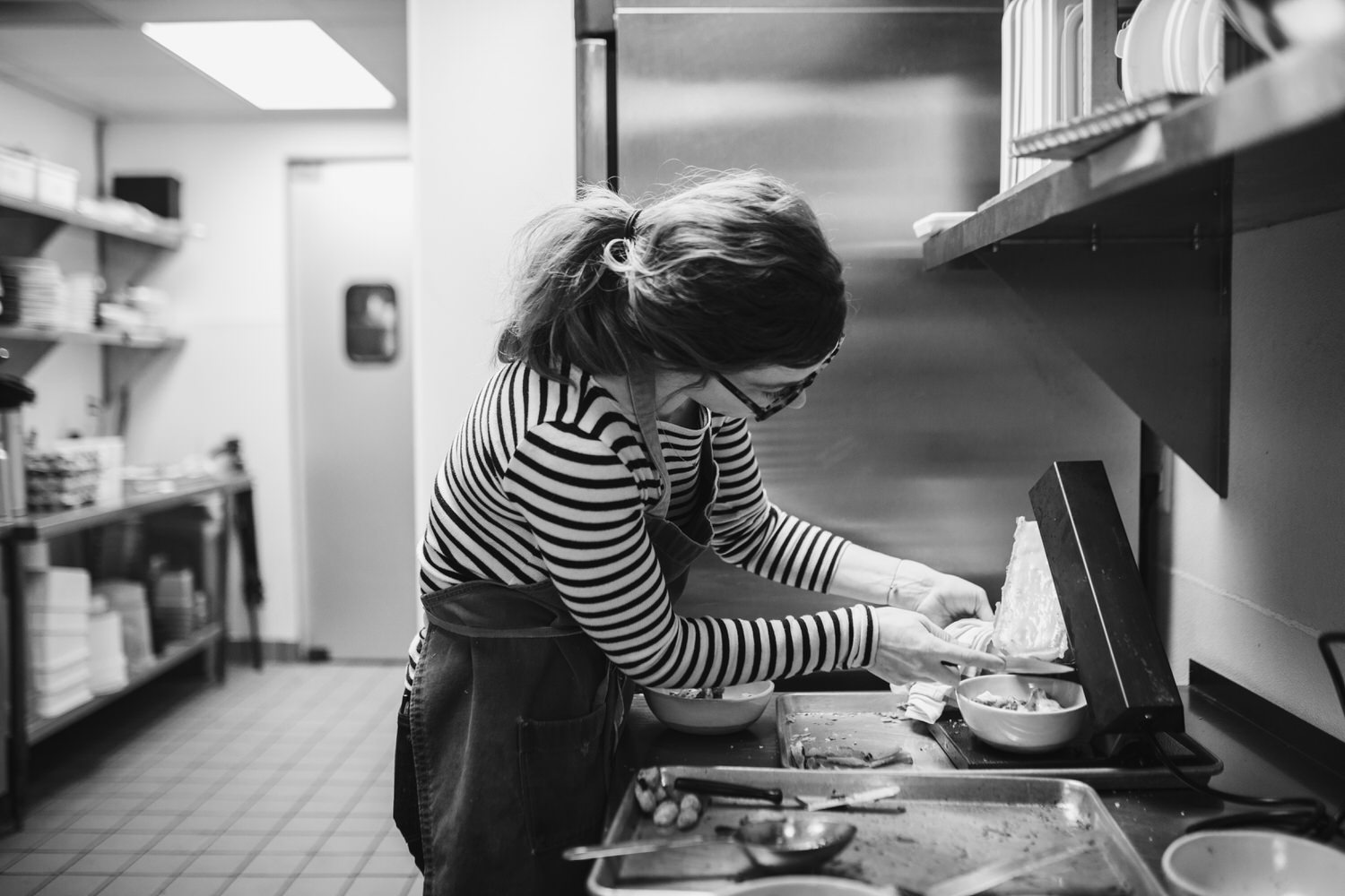 Head chef, Abby Olitzky, of Spencer Ann Arbor melting raclette cheese for service